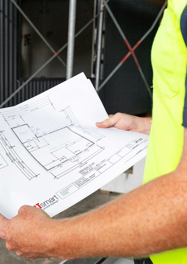 Builder holding Builtsmart classroom construction building plan